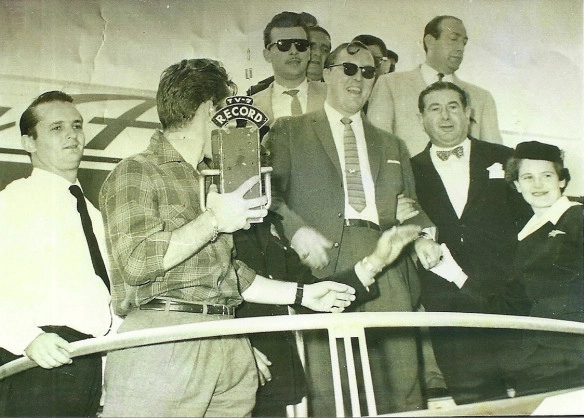Em 24 de abril de 1958, Silvio Luiz está `escondido´atrás do microfone tipo `tijolo´da Record na chegada de Bill Haley (à frente, de óculos), astro do Rock, ao Brasil, no Aeroporto de Congonhas. Foto: Divulgação
