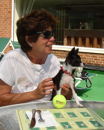 Até na mesa onde faz sua refeição, Maria Esther Bueno aparece com seu cãozinho e uma bola de tênis. Foto: Site Oficial