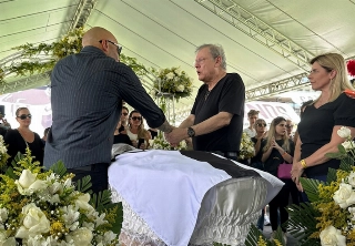 Edinho e Milton Neves junto ao caixão de Pelé, coberto pela bandeira santista. Foto: Lucas Reis