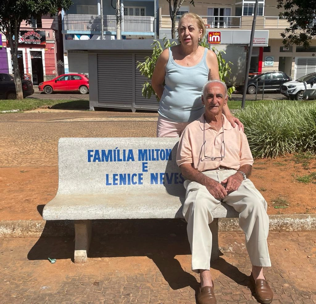 Sandra Magnoni e Hélio Magnoni (o Bibi), irmã e pai de Lenice no banco em homenagem à família Neves na Praça dos Andradas, em Muzambinho