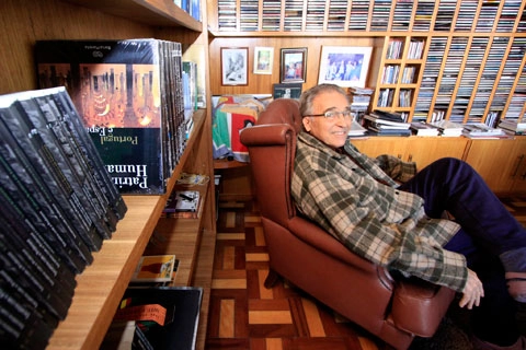 Cercado de livros, CDs e DVDs, o Professor Ruy Carlos Ostermann. Foto: UOL