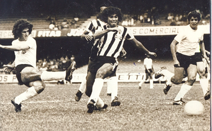 1/11/1975. Pelo Campeonato Brasileiro, o Timão bateu o Grêmio por 3 a 2. Na foto, Adílson arremata para o fundo das redes do goleiro Picasso (que não aparece na foto). Na jogada, ainda aparecem os zagueiros Bolívar (pai do jogador Bolívar), Beto Fuscão (atrás de Bolívar) e Vaguinho. Os outros gols do Timão foram marcados por Cláudio Marques (de pênalti) e Wladimir. Para o Grêmio, os dois gols foram do ponta Tarciso