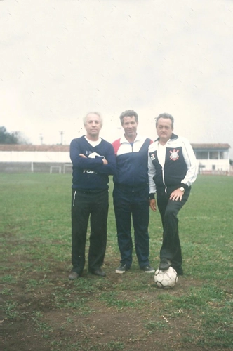 No gramado da Fazendinha em 1983, ano em que o Corinthians foi bicampeão paulista com um time que tinha Sócrates, Zenon Casagrande, Wladimir e Biro-Biro, entre outros. O preparador de goleiros Valdir Joaquim de Moraes, pessoa não identificada e o treinador Jorge Vieira. Foto: arquivo de Valdir Joaquim de Moraes