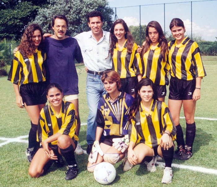 Na imagem, o grande cantor e compositor Toquinho aparece ao lado de Careca. Eles posaram para a foto junto com um time feminino