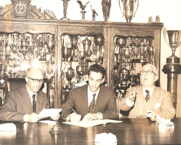 Em 13 de agosto de 1958, o elegante Valdir Joaquim de Moraes no centro da foto, assina seu contrato na sala da presidência do Palmeiras, após chegar do Renner, de Porto Alegre. À esquerda, na foto, está o presidente alviverde, Dr. Mário Beni e à direita o vice, Mário Frugiuelli. Foto: arquivo de Valdir Joaquim de Moraes