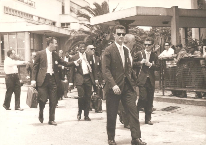 Os elegantes craques no corre-corre entre hotéis e aeroportos... Puxando a fila está Dudu. Atrás, com o braço esquerdo levantado, está Valdir Joaquim de Moraes conversando com Tupãzinho. Atrás de Tupãzinho estão Djalma Santos (parcialmente encoberto) e o técnico Aymoré Moreira, de óculos escuros. Entre Valdir e Tupãzinho, no fundo, aparecem três jogadores: Ademir da Guia, Djalma Dias e Minuca. Foto: arquivo de Valdir Joaquim de Moraes