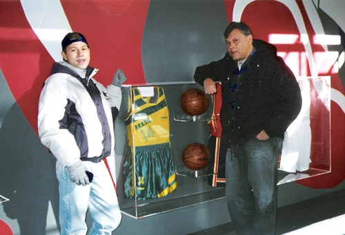 Na d&eacute;cada de 90, Milton Neves e seu filho Fabio Lucas posam para foto ao lado da camisa n&deg;14, que Oscar usou no c&eacute;lebre jogo Brasil 120 x 115 EUA, no Pan-americano de agosto de 87 em Indian&aacute;polis. A camisa est&aacute; no Museu da Fama do Basquete, em Springfield, desde dezembro daquele ano