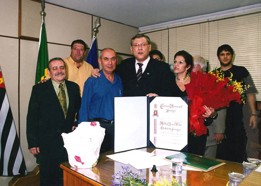 Em 26 de março de 2004, dia em que Milton Neves recebeu o Título de Cidadão de Santos, na Câmara Municipal do município paulista. Da esquerda para a direita: Orlando Tavares, o Morgado, ex-presidente da Portuguesa Santista, Luciano Facciolli, Kalef João Francisco, Milton Neves, Lenice Neves e Netto Neves. Foto: arquivo pessoal de Milton Neves