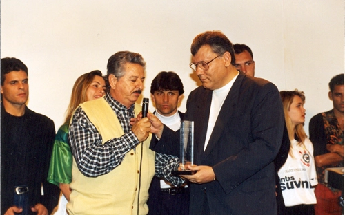 Ao microfone, dois craques: Fiori Giglioti e Milton Neves. A dupla é observada pelo atacante Paulinho McLaren e pelo lateral Edinho. Atrás de Milton Neves estavam ainda Velloso (encoberto) e Bentinho (no canto), atletas premiados no troféu 