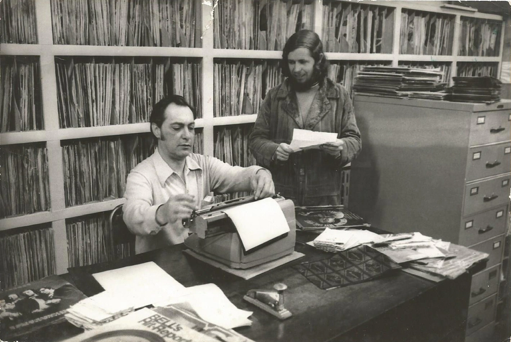 Na discoteca da Rádio Jovem Pan, no Aeroporto, Fausto Canova datilografa a seleção de músicas ao lado de Picá. Foto: arquivo pessoal de Picá