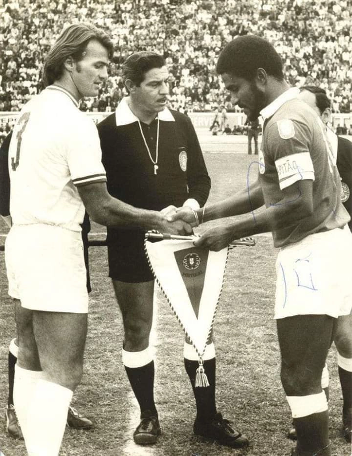 Os capitães do América-RJ e do Benfica, Alex e Eusébio, respectivamente, trocam flâmulas em 8 de agosto de 1973,  decisão do III Troféu TAP, partida disputada em Luanda (Angola). O América sagrou-se campeão após perder o primeiro jogo por 2 a 0, vencer o segundo por 1 a 0 e ganhar nos pênaltis por 8 a 7. Foto: arquivo pessoal de Alex