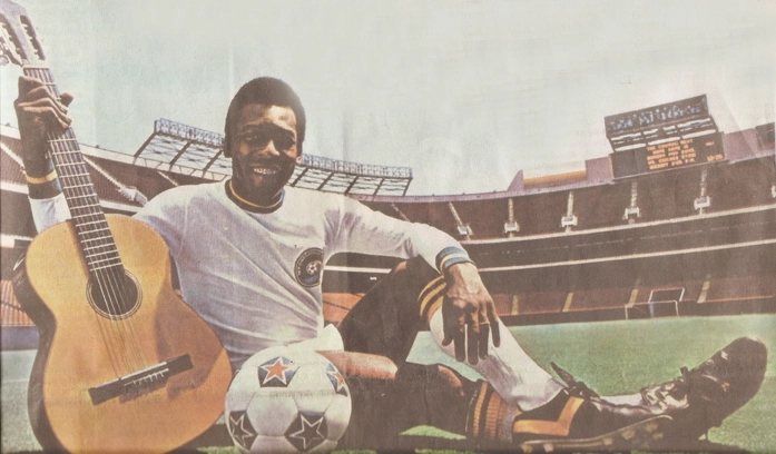 Nos Estados Unidos, com a camisa do Cosmos de Nova Iorque, Pelé e o violão, companheiro que sempre esteve com o ele, que já compôs muitas músicas. Reprodução: O Estado de São Paulo