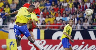 Na Copa de 2002, Roque Júnior sofre falta de Marc Wilmots e o árbitro anulou o gol da Bélgica, que perdeu para a seleção brasileira por 2 a 0. Ao fundo, Cafu. Foto: AFP PHOTO PHILIPPE HUGUEN/ via UOL