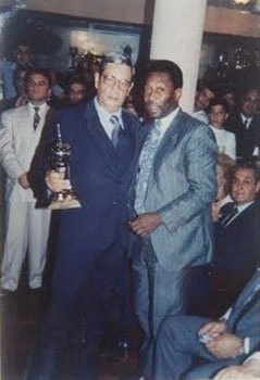 Carlos (segurando troféu) e o Rei Pelé, estão juntos e abraçados. Foto enviada por Carlos Argenti