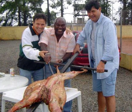 Em 2004, o ex-ponta-esquerda Edu, ao lado dos amigos Cido (de azul) e Leo, pronto para devorar um carneiro.