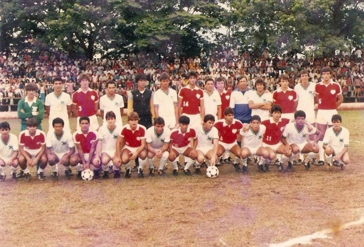 Amistoso ente o combinado de Neto e Giba x Destilaria Pioneiros, em 1985. Da esquerda para a direita, em pé: Neto é o nono e Giba é o décimo segundo. Agachado: Marco Antônio Boiadeiro é o segundo. Foto enviada por Eduardo Garcia