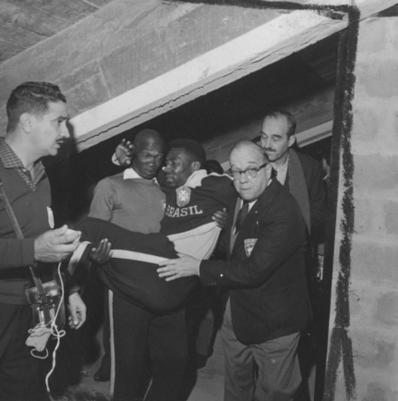 Em 1962, Mário Américo, massagista da Seleção Brasileira, carrega Pelé enquanto Paulo Machado de Carvalho abre passagem e protege o Rei. À direita, o então presidente da Federação Paulista de Futebol, João Mendonça Falcão. Foto: Divulgação