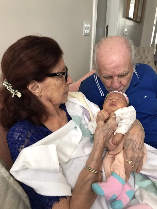 Ao lado da esposa, beijando a recém-nascida bisneta Maria Isabel, em 11 de dezembro de 2023. Foto: arquivo pessoal de Evaristo de Macedo