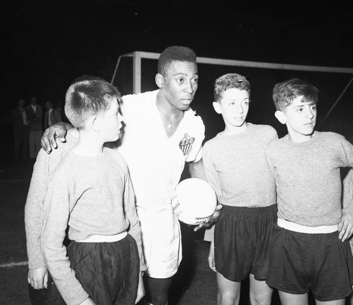 Garotos italianos pedem para o fotógrafo eternizar o momento ao lado de Pelé, em 1963, no San Siro, em Milão. Crédito da foto My Ear