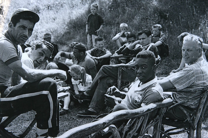 No centro da imagem, está o ainda garoto Pelé, tendo Nilton Santos (de boné) e Gylmar ao seu lado. Atrás do Rei (apoiando a cabeça com a mão), está Pepe, tendo Garrincha aparecendo atrás. Mais para a esquerda, de touca, aparece o preparador físico Paulo Amaral. Foto: In My Ear 