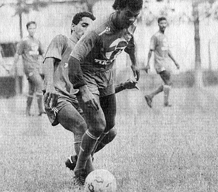 Zé Carlos (com o rosto encoberto) disputa a bola com o meia Zico, durante treino do São José na ADC Philips, em 1990. Crédito da foto: Nelson Almeida