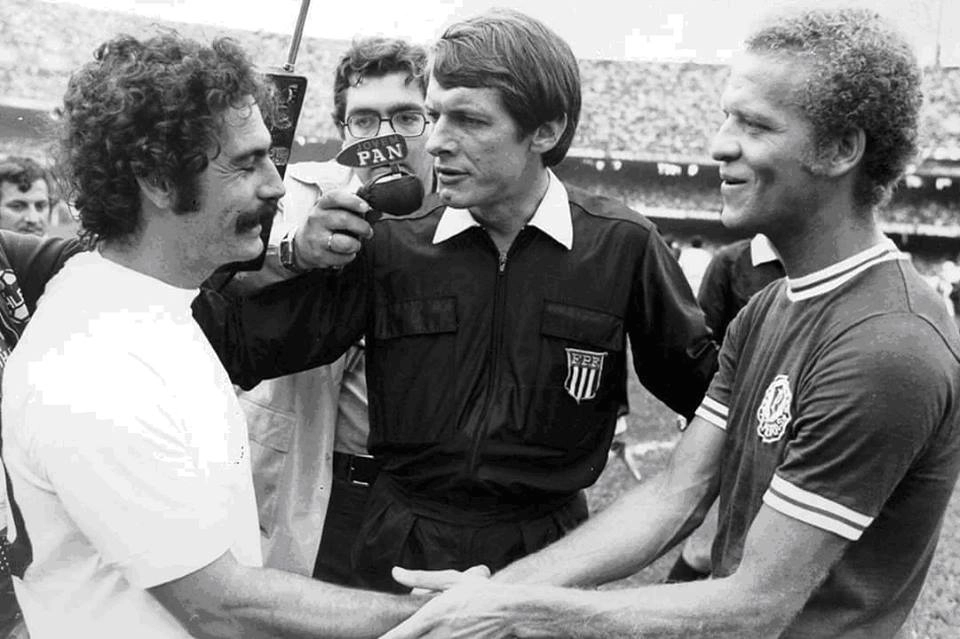 Rivellino cumprimenta Ademir da Guia antes da final entre Corinthians e Palmeiras no Morumbi, em 22 de dezembro de 1974. No centro da foto, o árbitro Dulcídio Wanderley Boschilia. Atrás, com o microfone da Rádio Jovem Pan, Fausto Silva. Foto: Divulgação