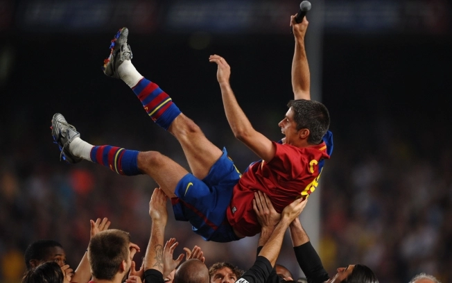 Sylvinho é erguido pelos colegas após mais um título pelo Barça. Foto: iG/AFP