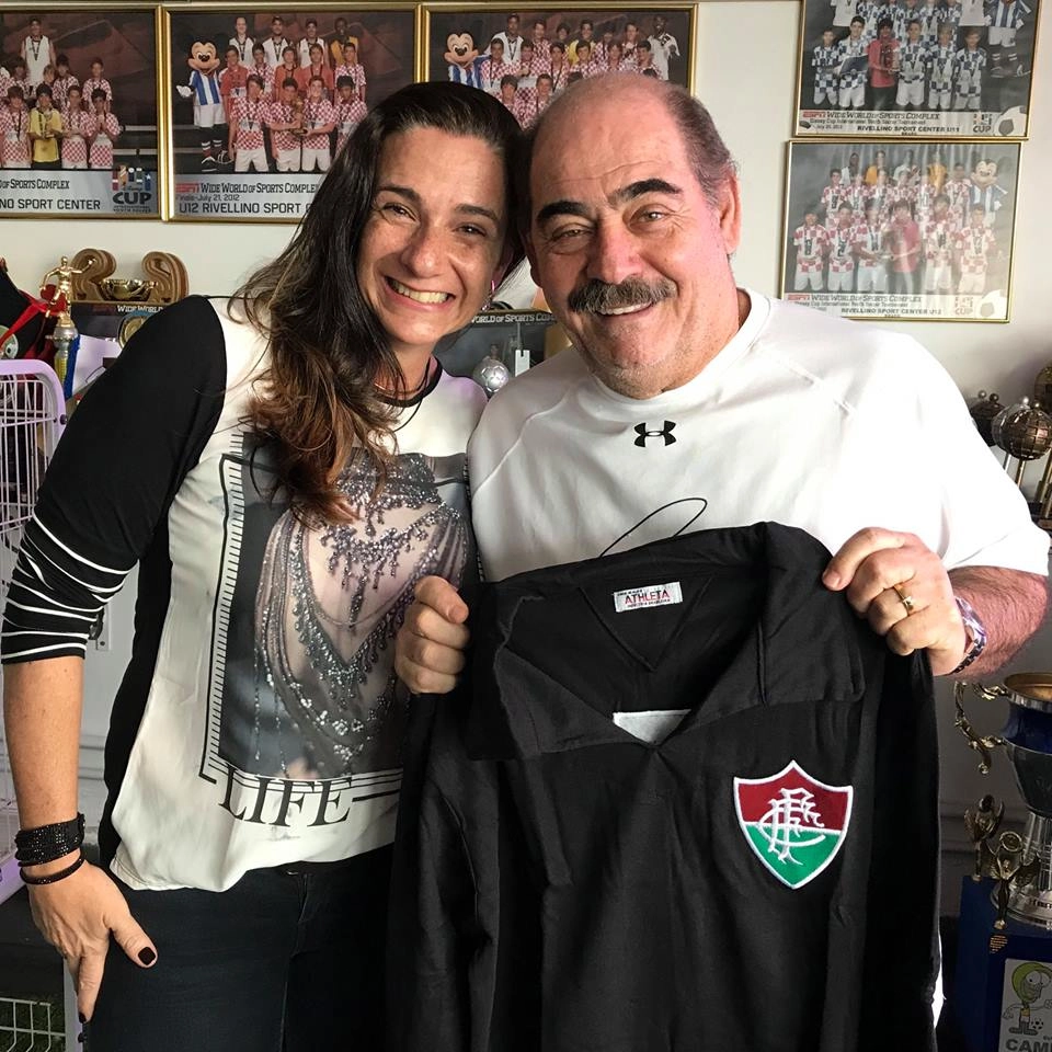 Pati Venerando, filha de Félix, ao lado de Rivellino em 1º de agosto de 2017. Rivellino posa com uma camisa retrô de Félix após ter sido entrevistado pela equipe do Acervo da Bola. Foto: arquivo pessoal de Pati Venerando