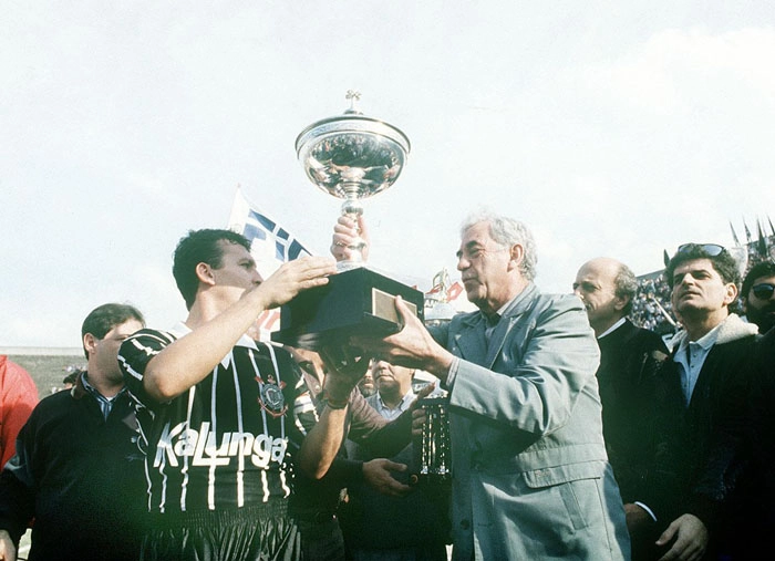 Neto, jogador do Corinthians, recebe prêmio das mãos de Olímpio da Silva e Sá, diretor do jornal A Gazeta Esportiva, após a partida contra o Santos FC, válida pelo Campeonato Paulista de 1990. Foto: Agência Gazeta Press