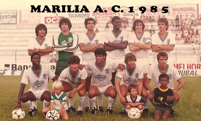 Forma&ccedil;&atilde;o da equipe do Mar&iacute;lia em 1985. Em p&eacute;, da esquerda para a direita: Valdir, Luiz Andrade, Dimas, Bernardo, Fernando Narigudo e Carlos. Agachados. Giba, Pop&eacute;ia (ex-Internacional), H&eacute;lio, L&uacute;cio e Careca Bianchesi. E o mascote &agrave; frente de Lucio (pen&uacute;ltimo agachado) &eacute; Ulisses Costa. Foto enviada por Wanderley 