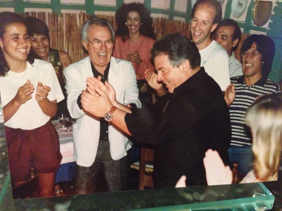 J&uacute;lio Mazzei, no centro de blazer claro, ajuda nas palmas para Luciano do Valle, de camisa preta em destaque