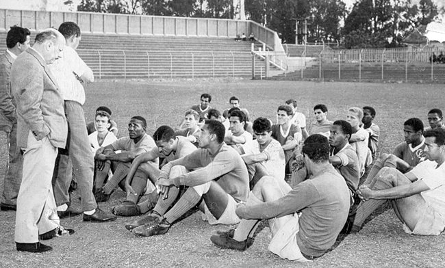 A foto &eacute; de 1963. Em p&eacute;: o primeiro, com a m&atilde;o no bolso &eacute; Ferruccio Sandoli e os outros dois s&atilde;o Arnaldo Tirone e Geninho (da esquerda para &agrave; direita). Eles conversam com os jogadores do Palmeiras. na primeira fileira, da esquerda para a direita, o segundo &eacute; Djalma Santos, depois Tarciso, Dorival e Serv&iacute;lio (com as m&atilde;oes nas canelas). Na fileira subsequente, atr&aacute;s de Tarciso est&aacute; Valdemar Carabina e depois Alencar, Paulo Le&atilde;o e Aldemar. Atr&aacute;s de Alencar est&aacute; Ademir da Guia e &agrave; direita na foto aparece Renato. Na &uacute;ltima fileira, o primeiro &agrave; esquerda &eacute; Vav&aacute;, o quarto &eacute; Reinaldo Lap&atilde;o e o &uacute;ltimo &eacute; Nilo