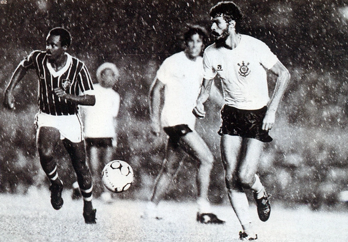Foto do início dos anos 80 mostra Sócrates carregando a bola, sendo marcado pelo meia Assis. Ao fundo, aparecem Biro-Biro e Paulinho. Foto: Placar