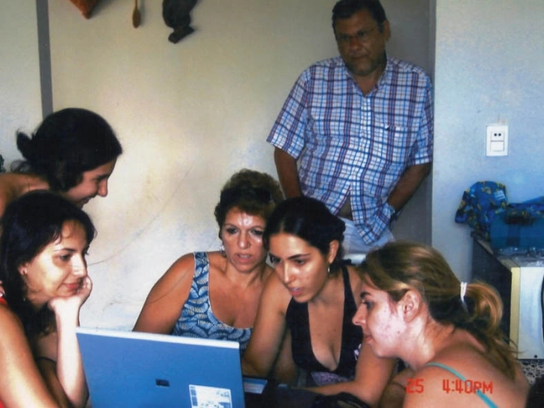 Milton observa sua esposa Lenice (de vestido azul) e outras familiares, de olho no notebook