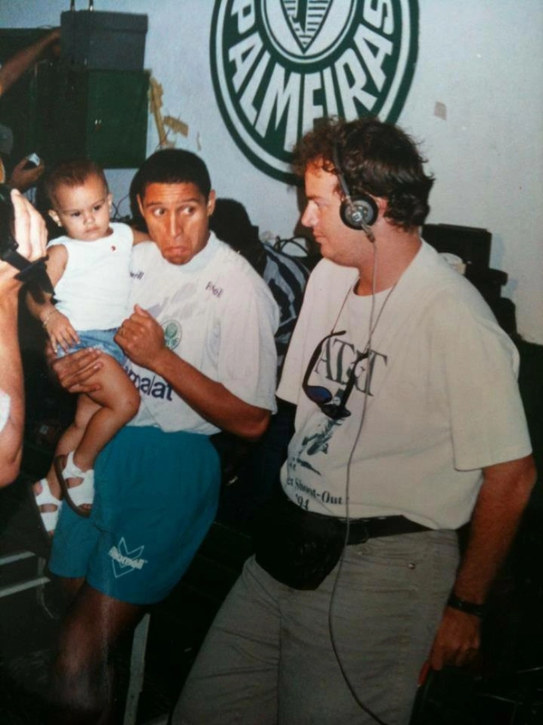 Roberto Carlos com filho no colo, nos vestiários do Parque Antártica.. O lateral-esquerdo atuou no Palmeiras entre 1994 e 1995. À direita, o repórter Marcelo di Lallo