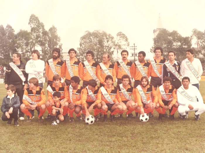 Manhã fria na capital paulistana durante o jogo de entrega de faixas à equipe da SDR, vencedora de mais um Desafio ao Galo. O segundo em pé, da esquerda para a direita é Écio Pasca. O sexto agachado, de uniforme laranja, é Manfrini. Atrás, à direita, a torre da igreja Santuário das Almas, na Rua Guaporé. Foto: Sarkis