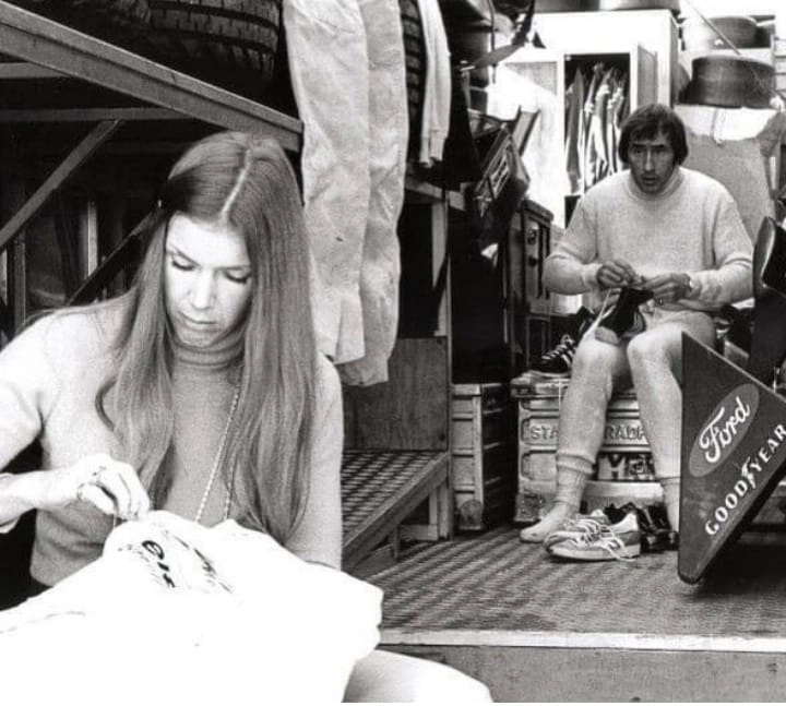 Helen, esposa de Jackie Stewart costura o macacão do marido, que ao fundo está passando o cadarço em sua sapatilha, em fim de semana de Fórmula 1 no começo dos anos 70. Foto: Divulgação