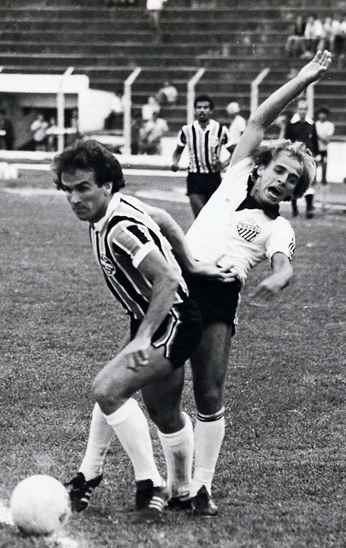 Dura disputa de bola entre o gremista Vítor Hugo e Zé Luiz. O lateral Vílson Cavalo do Tricolor Gaúcho observa de longe a troca de empurrões entre os jogadores