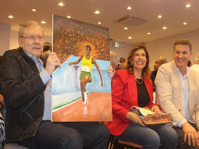 Milton Neves com quadro retratando João do Pulo em 27 de maio de 2024, durante homenagem que o jornalista recebeu em Pindamonhangaba, no Hotel Intercity Pátio Pinda. Foto: Conexão Vale