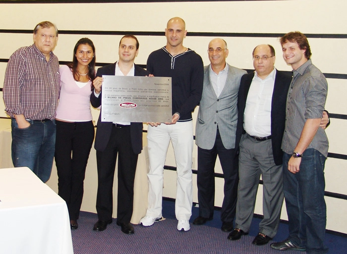 Milton Neves, Carolina, Alexandre, Marcos, Sérgio, Samuel e Fábio com a placa da Pirelli alusiva a marca de um milhão de pneus vendidos pela Della Via