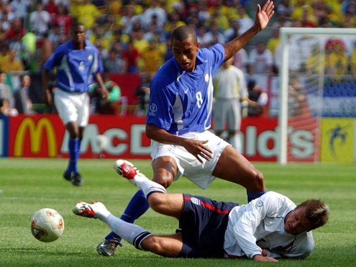 Gilberto Silva disputa jogada com Beckham (no chão). Ao fundo, vemos zagueiro Roque Júnior e o goleiro Marcos. Foto: UOL