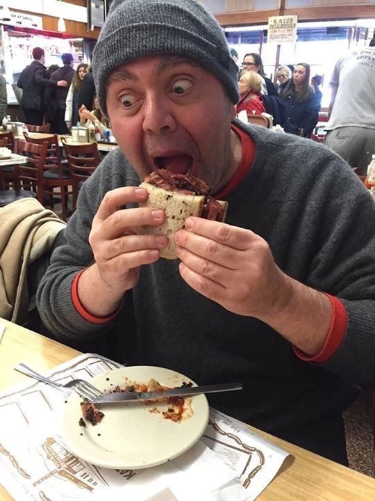 Caca Rosset degustando delicadamente um sanduíche de pastrami, no dia 23 de março de 2015