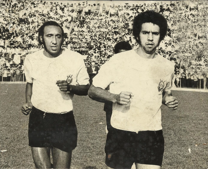 Zé Roberto e Tião entrando no gramado do Pacaembu em 1975 para um jogo do Corinthians. Atrás de Tião, encoberto, Marco Antonio Visgo