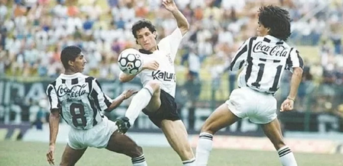 Márcio, volante do Corinthians, disputa a bola com os santistas Axel e Sérgio Manoel em jogo do Brasileirão de 1990. Crédito da foto: Fernando Santos/Folhapress, via Portal UOL.