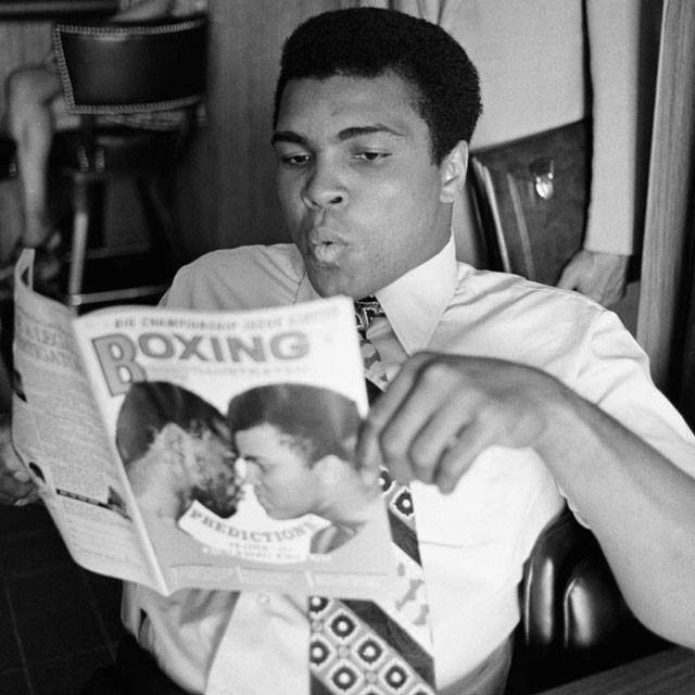 Em 23 de maio de 1972, lendo a revista Boxing, na qual a capa mostrava ele próprio e Joe Frazier, um de seus maiores rivais. Foto: Reprodução