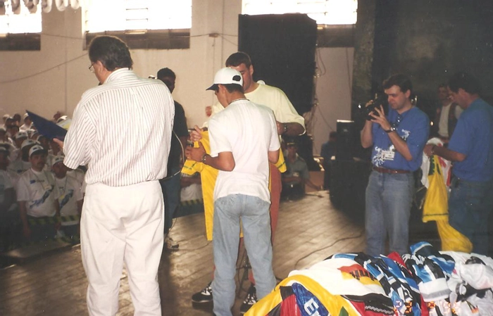 Em 1996, Milton Neves apresentando evento da Deca-Hydra. Atrás do homem de boné, parcialmente encoberto, Zetti
