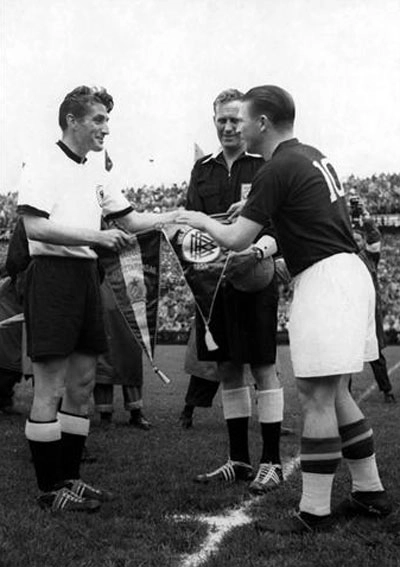 Da esquerda para a direita, o capitão alemão Fritz troca a flâmula com o também capitão, mas da Hungria, o grande atacante Puskas. Essa partida terminaria 3 a 2 para a Alemanha Ocidental, que se sagrou-se campeã. Foto: Fifa