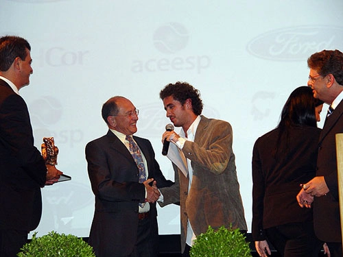 O brilhante narrador recebe o mais do que merecido troféu das mãos de Felipe Andreoli que, juntamente com seu pai, Luiz Andreoli, apresentou o evento.
