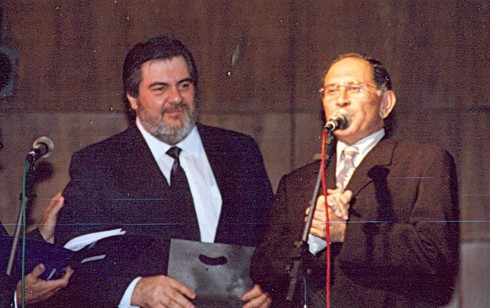 José Silvério fala ao microfone, observado por Afanásio Jazadji. Foto: Arquivo ACEESP