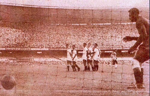 O goleiro Azca, da seleção do Peru, observa imóvel a bola bater na sua rede após cobrança perfeita de falta de Didi. Naquela tarde de Maracanã lotado, o Brasil venceu o jogo por 1 a 0 e obteve classificação para a Copa do Mundo de 1958

